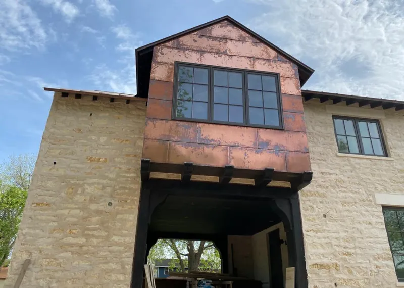 Copper metal panel facade on a stone building for Roof Repair in Dakota Ridge
